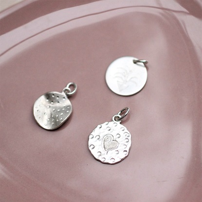 tre vedhæng i sølv, som er lavet på forskellige måder.